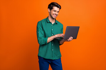 Aufkleber - Photo of cute cheerful man dressed green shirt texting apple samsung modern device isolated orange color background