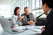 © Marko Geber - Middle aged couple reaching an agreement with a car salesmen about a purchase of a vehicle at the car dealership