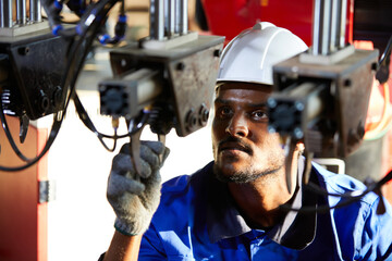 Wall Mural - African engineer or worker checking and fixing machine in robot factory