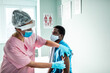 © Marko Geber - Young African American man getting vaccinated by a health worker at the hospital