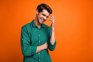 Poster - Photo of good mood positive guy wear green shirt smiling empty space isolated orange color background