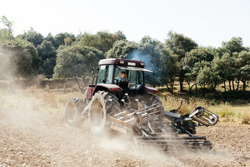 Young woman driving tractor in countryside on sunny day