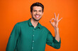 Leinwandbild Motiv Photo of good mood funky man dressed green shirt showing okey gesture isolated orange color background