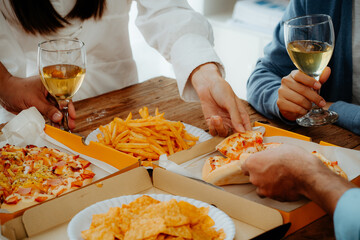 Group of young asian office girl friends having fun and celebrating pizza on table during party