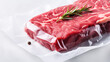 Fresh red raw beef ribeye steak sealed in transparent plastic vacuum pack on white marble table background, copy space. 