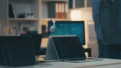 IT specialists talking in office with computers and laptops, programmers at work