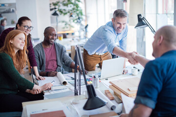 Group of people reaching a agreement while working together on a project in a startup company office