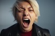 © Fotograf - A woman wearing a leather jacket with her mouth open. This image can be used to depict surprise, shock, or excitement. It is suitable for various creative projects and can be used to add a touch of ed