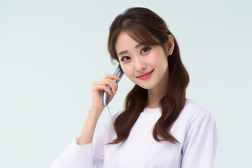 Aufkleber - A woman wearing a white shirt is seen talking on a cell phone. This image can be used to depict modern communication, business calls, or technology in everyday life.