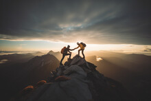 Two Climbers Manage To Ascend To The Summit Of A Mountain Sunset,after Hard Teamwork,reaping The Rewards Of Collaboration To Achieve Common Goals And Accomplishments, Attaining Success Through Effort 