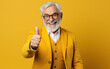 © AI_images - A happy smiling senior man with thumb up, colorfully dressed, on yellow copy space background