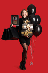 Poster - Young woman with shopping bags, gifts and balloons on red background. Black Friday sale