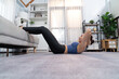 Young attractive asian woman in sportswear lies on the floor and doing sit-ups on the crouch, aiding targeting on abs muscle for effective home exercise routine. Vigorous
