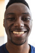 Portrait of happy african american man with short black hair smiling at home