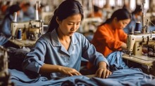 Asian Worker Sewing Clothing In Garment Factory.