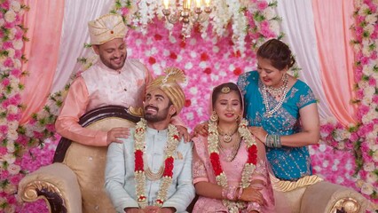 Wall Mural - Happy Indian middle aged Father and Mother with newlywed bride and groom posing to camera on wedding stage - concept of family bonding, Marriage ceremony, proud parents