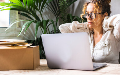 Wall Mural - Tired, exhausted adult entrepreneur woman with a laptop, problems with the project, feeling depressed, laziness in the home office in the living room. Small business bad day. Female work on computer