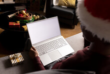 African American Man At Home In Christmas Hat Having Video Call On Laptop With Copy Space On Screen