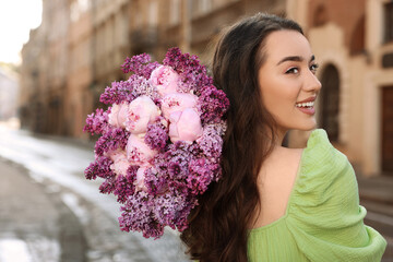 Poster - Beautiful woman with bouquet of spring flowers on city street