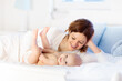 © famveldman - Mother and baby on a white bed