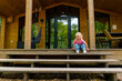 © Guys Who Shoot - smiling cute little girl in stylish clothes on the terrace of a wooden house in the woods