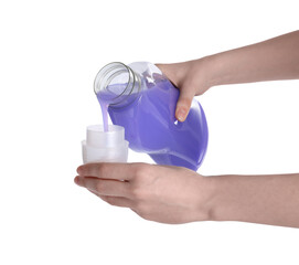 Wall Mural - Woman pouring fabric softener from bottle into cap on white background, closeup