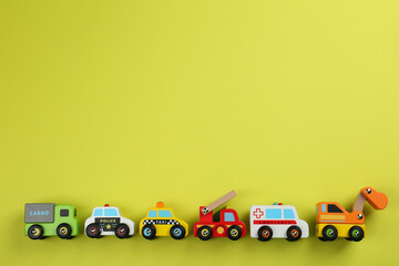 Canvas Print - Different toy cars for children on yellow background, flat lay. Space for text