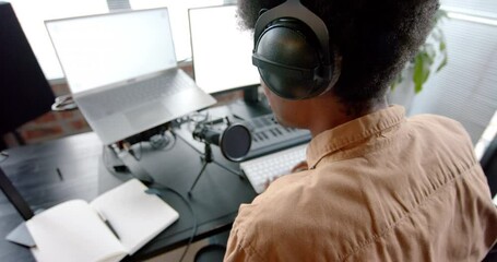 Wall Mural - african american man in headphones podcasting at home, slow motion