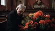 © Alina Nikitaeva - Senior man grieving putting flower bouquet on a coffin in the church cemetery during funeral. Love for ages