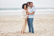 © Talia Mdlungu/peopleimages.com - Hug, portrait and a family at the beach for a vacation, travel or walking by the ocean. Happy, care and a young mother, father and girl kid at the sea for a holiday, bonding or together in summer