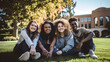 © Vimukthi - multiracial classmate friends sitting together on the grass at campus college park