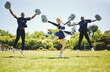 © Sharne/peopleimages.com - Cheerleader group portrait, smile and people jump, dance and performance on field outdoor for exercise, workout or training. Happy, cheerleading team and support at event, sport competition or energy
