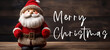 Merry Christmas xmas banner greeting card with text - Santa Claus / Nicholas figure on wooden wood table