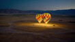 montgolfières en préparation pour le décollage au levé du jour dans le désert, éclairées à la lueur des torchères