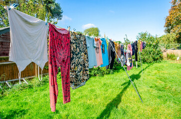 Wall Mural - Washing drying outside on a washing line. Clothes dry quickly in the autumn sunshine.