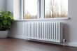 A steel radiator is positioned under a windowsill on a white wall