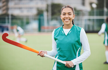 Poster - Female, person and happy for hockey with stick in hand on field for training in portrait. Girl, hold and smile with confidence for sports with pose, stand and equipment for match, game or fitness