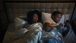 © Yuliia - Irritated angry African American woman girlfriend trying sleep push man boyfriend husband using smartphone gadget addict addicted playing game online at late night mobile phone in bed couple family