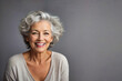 Hermosa mujer de 60 años de edad con el pelo gris riendo y sonriendo con dentadura perfecta.