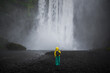 Skogafoss Waterfall with a model in front of the falls in Iceland