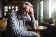 © ChaoticMind - Headache pain. Unhappy middle aged senior man suffering from headache sick rubbing temples at home. Mature old senior grandfather touching temples experiencing stress. Man feeling pain hurt in head