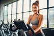 Attractive woman on stationary exercise bike at gym, maintaining a healthy lifestyle, focused on exercises