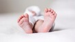 © Generative AI - Tiny feet Closeup of baby feet with flower on it lying in bed : Generative AI