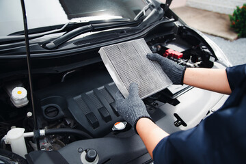 Auto mechanic holding old car air filter pollution to checking cleaning and replacing new for fix heat car air conditioner service maintenance.