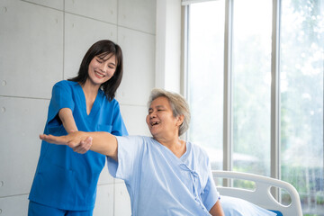 Beautiful asian nurse taking care of senior woman to exercise at hospital. She feeling happy when take care senior woman. Healthcare, Retirement, Volunteer, Caregiver and Lifestyle concept.