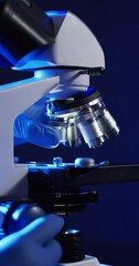Poster - Vertical video of close up of laboratory microscope with copy space on blue background