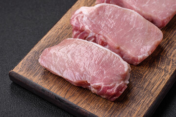 Raw fresh pork meat steak with salt, spices and herbs