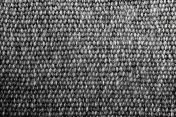 Poster - Top view of a seamless black and white knit fabric pattern on a close up gray cotton heather background with selective focus