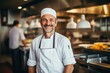 © Baba Images - Smiling portrait of a caucasian chef working in a restaurant kitchen