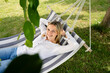 beautiful, blond young woman is relaxing in hammock in garden